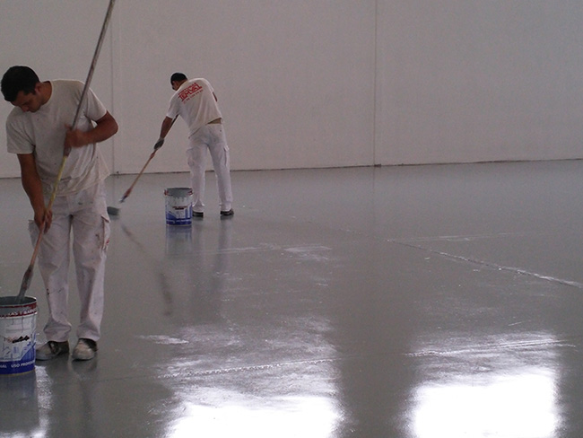 trabajadores pintando suelo